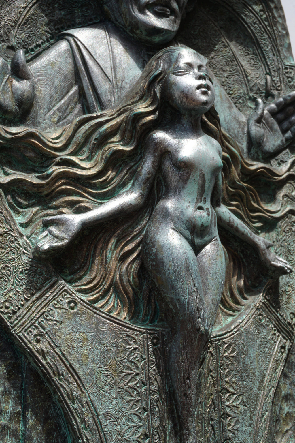 Bronze sculpture of a nude figure with flowing hair and draped fabric