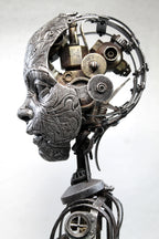 Metallic sculpture of a head with mechanical components on a white background