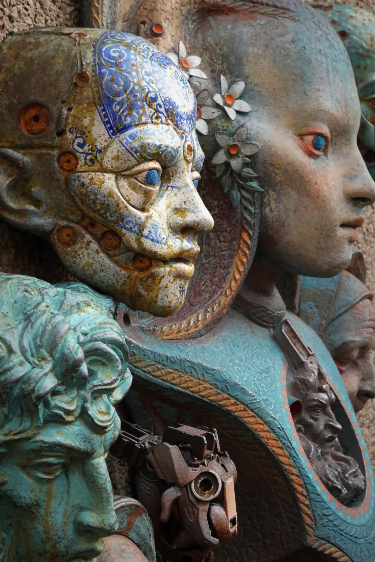 Close-up of a detailed sculpture with human-like faces and decorative elements.
