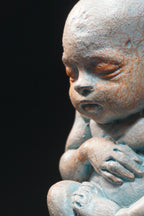 Statue of a baby with a dark background